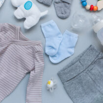 Baby concept. Baby cloth and goods on light blue background. Place for text. View from above. Flat Lay